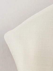 Macro shot of white woven fabric texture showing detailed plain weave and fibers