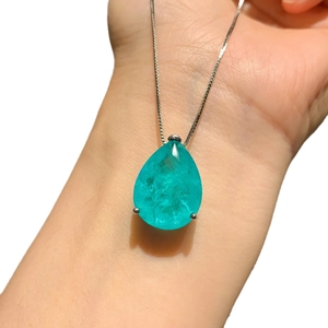 Pendentif en forme de poire avec pierre bleue sur main pour voir la taille