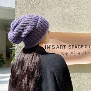 Thick purple chunky knit beanie hat with rolled edge for winter, shown on a model