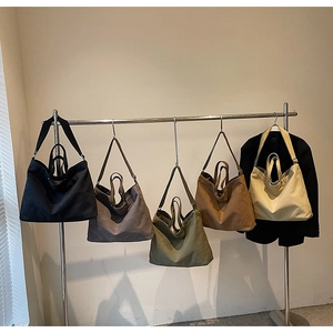 Hanging canvas tote bags in various colors showing large capacity and drape on a rack