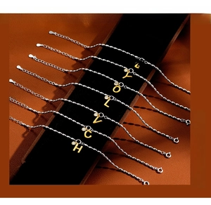 Detail of S925 silver bracelets with gold letter charms and sparkling zircon stones