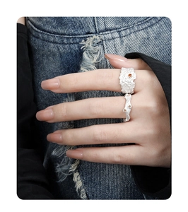 Close-up of irregular textured silver rings with orange gemstones on model hands