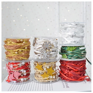 Detail of assorted Christmas ribbons with gold stars, pink bows, and pearl embellishments