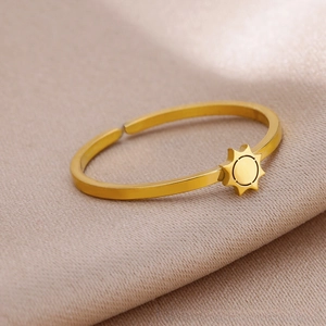 Close-up of golden adjustable open sun ring on a textured fabric background