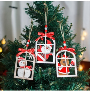 Close-up of wooden Christmas window ornaments with snowman and Santa hanging on a tree
