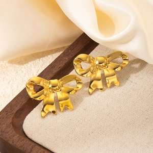 Elegant gold bow earrings with pleated design on luxury champagne satin fabric