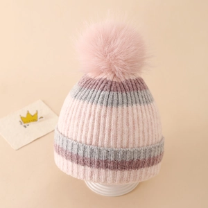 Close-up of winter knit hat featuring pink striped pattern and fluffy pom-pom detail