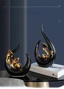 Close-up of modern abstract ceramic sculpture set with black and gold polished finish