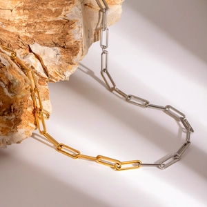 Modern two-tone gold and silver stainless steel paperclip chain necklace on stone