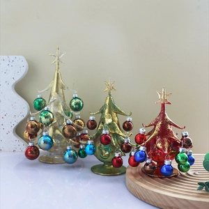Three colorful miniature glass Christmas trees with metallic finish on wooden bases