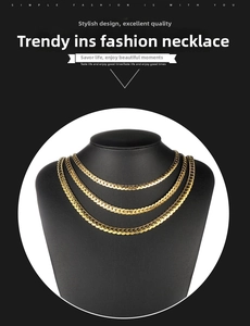 Close-up of triple-layered golden flat snake and Cuban chain necklaces on jewelry bust