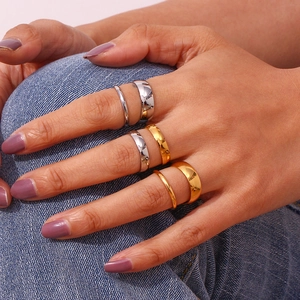 Close-up of hand wearing 18K gold and silver minimalist stackable stainless steel rings