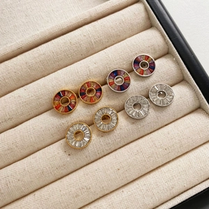 Four pairs of stainless steel stud earrings with colorful zircons in a jewelry box