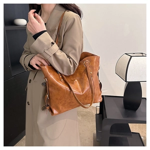 Caramel tote bag with glossy texture shown on model in a minimalist lifestyle setting