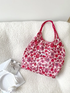 Detail of red floral canvas tote bag with drawstrings and have a nice day label
