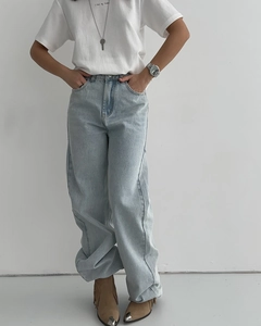 Détail d'un jean large bleu clair à taille haute avec un aspect délavé vintage