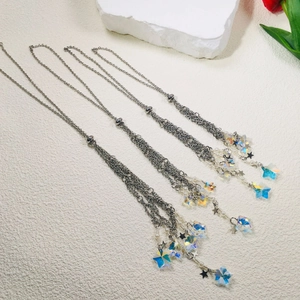 Detail of silver layered fringe necklaces featuring iridescent star beads and metal charms