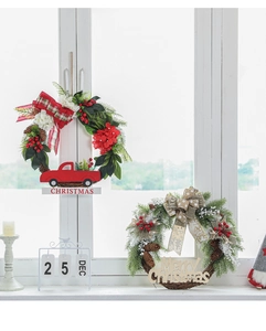 Detail of Christmas wreath with red truck and wooden Merry Christmas sign on window