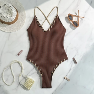 Detailed flat lay of dark brown ribbed swimsuit with beige lace-up eyelet accents