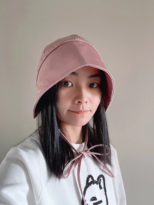 Detail view of the pink satin sun hat with decorative tie straps for women