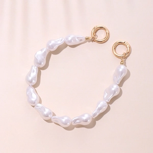 Elegant acrylic pearl phone strap with golden spring clasps on a soft pink background