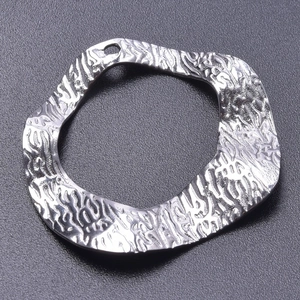 Macro detail of silver geometric pendant featuring a textured hammered finish for DIY jewelry