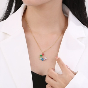 Close-up of a gold chain necklace with a colorful rainbow crystal petal pendant on a model