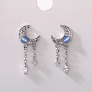 Detail of silver moon tassel earrings with blue stones and clear zircon on a display