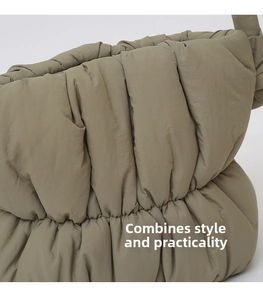 Detailed view of the olive green puffer bag featuring vertical pleated quilting texture