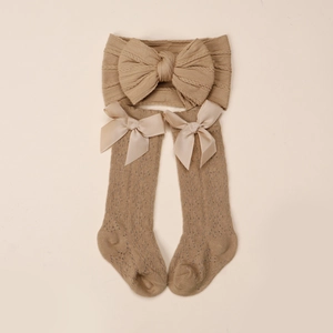 Détail de l'ensemble bandeau bébé à nœud et chaussettes montantes en tricot couleur kaki