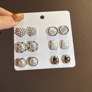 Dettaglio di 6 paia di orecchini con perle e strass su un supporto per display