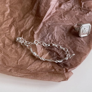 Detailed shot of handmade S925 silver twisted chain bracelet and vintage floral relief ring