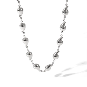 Macro view of polished silver water drop pendants on a fine titanium steel chain necklace