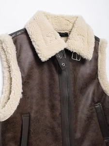 Detail view of dark brown faux leather vest featuring thick cream faux shearling collar