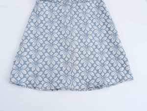 Detailansicht des blauen Vintage-Jacquard-Stoffs mit floralem Reliefmuster auf dem Kleid