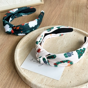 Detail of Christmas knot headbands with festive Santa and tree patterns on stone tray