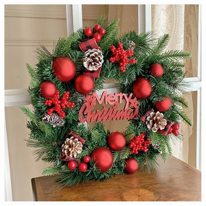 Detail von Weihnachtskranz mit roten Beeren, Zapfen und Merry Christmas Schild