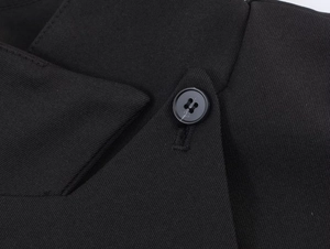 Detail of black blazer lapel featuring high-quality twill fabric and a 4-hole button