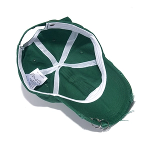 Detail of dark green cotton baseball cap showing interior lining and metal ring accents