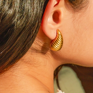 Close-up of 18k gold-plated stainless steel striped drop earrings on model
