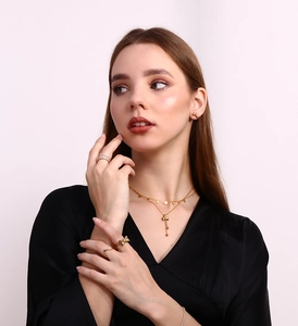 Detailed view of model wearing a 18K gold plated bow jewelry set with necklace and earrings