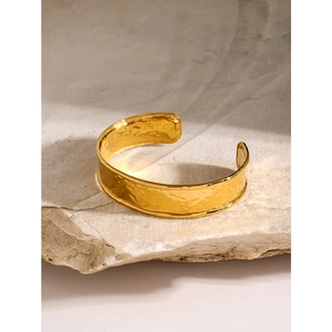Polished 18k gold stainless steel open bangle with unique hammered texture on stone base