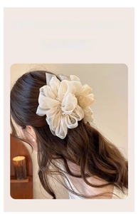 Detail einer cremefarbenen Chiffon-Haarklammer mit Strass in einer halboffenen Frisur