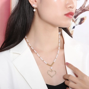 Parure collier et boucles d'oreilles perles avec pendentif cœur portée par un mannequin
