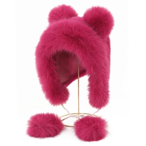 Detail of rose red faux fur trapper hat featuring four plush pom-poms on metal stand