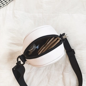Interior view of white round PU leather crossbody bag showing spacious storage and black strap