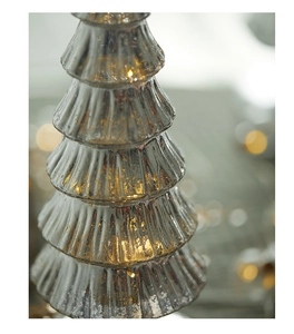 Detail of mercury glass Christmas tree with warm LED lights and festive bokeh background