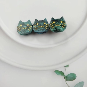 Detailed close-up of dark green marble pattern acetate hair clip with triple cat design