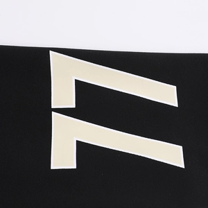 Detail of white number 77 print on black fabric texture of a loose streetwear sweatshirt
