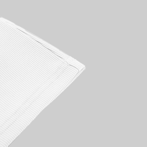 Macro view of white ribbed knit fabric detailing stitching and fine texture of the crop top